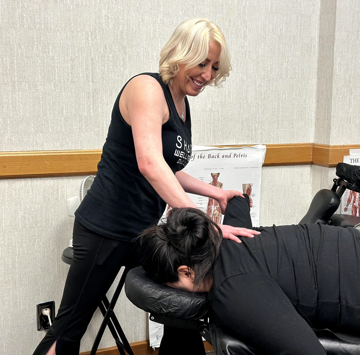 Elle giving a chair massage at a wellness event
